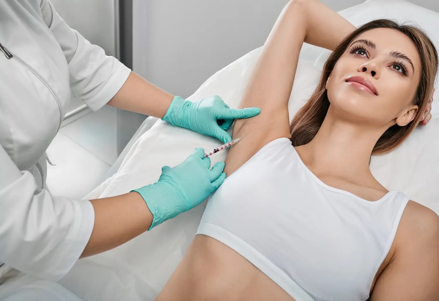Achselhöhleninjektionen zur Vorbeugung von übermäßigem Schwitzen bei einer Patientin mit einer Kosmetikerin in der Kosmetik
